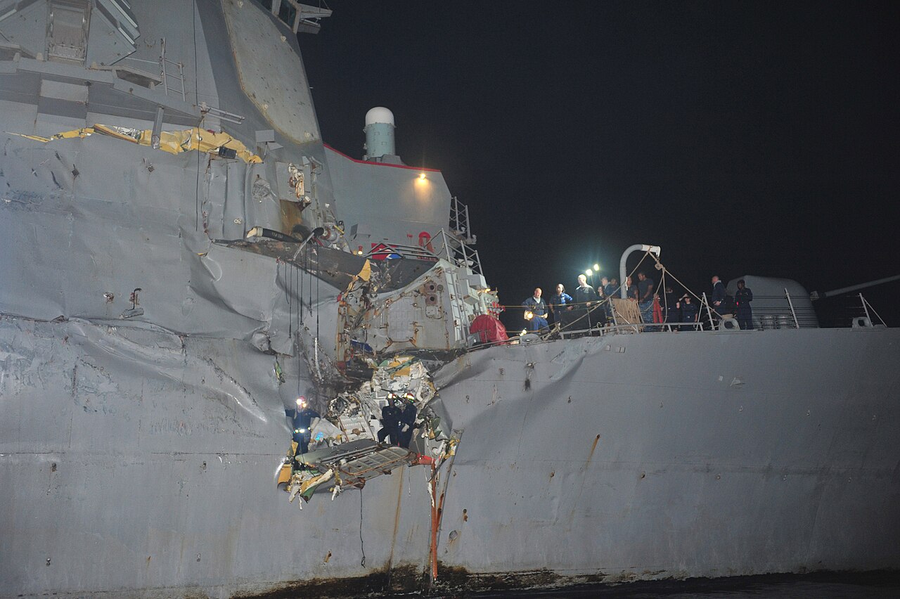 US Navy warship patrolling the Strait of Hormuz with oil tanker in background