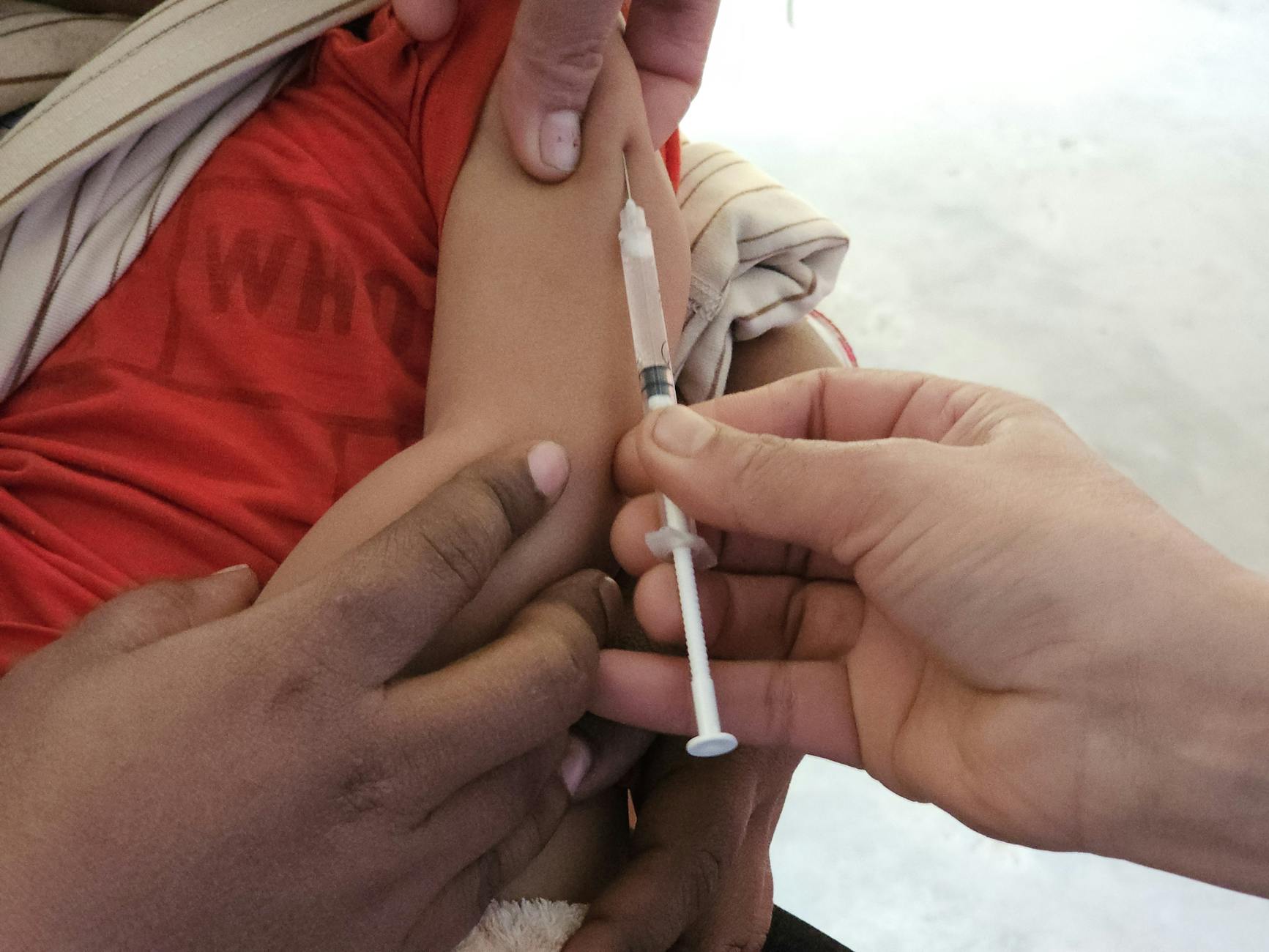 Children receiving measles vaccination at a campaign site in Bangladesh