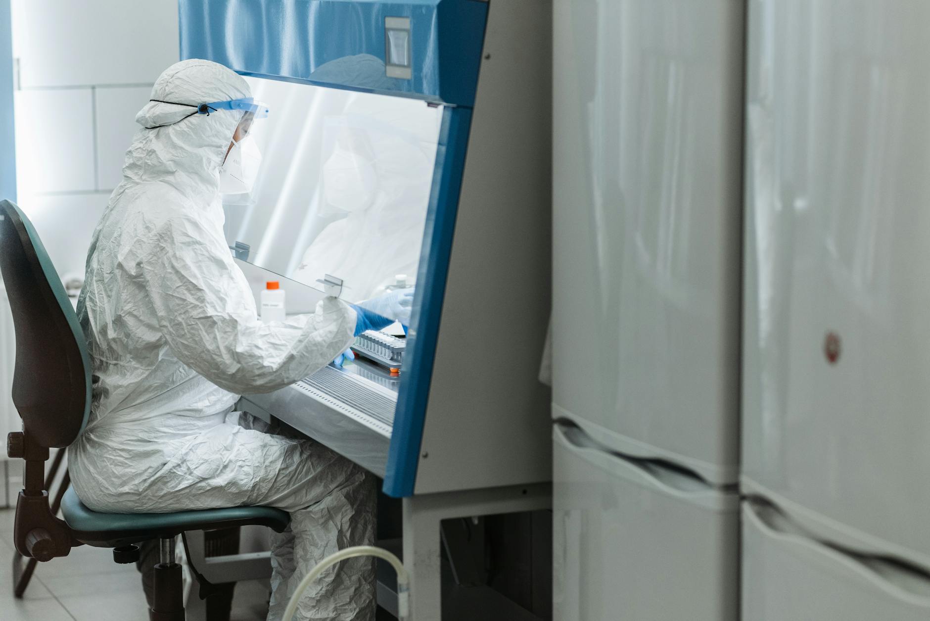 Laboratory technician handling avian influenza samples in biosafety gear